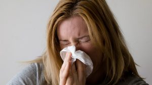 Influenzás nő orrot fúj
